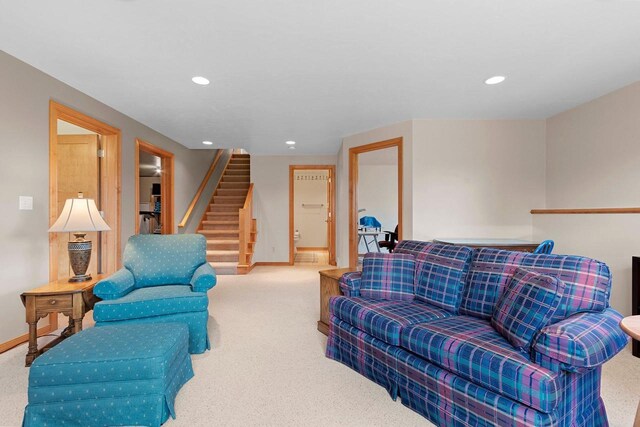 carpeted living area featuring recessed lighting, baseboards, and stairs