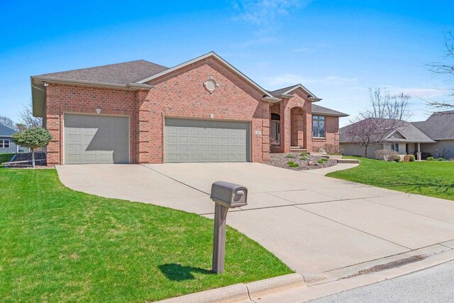 view of front of house featuring concrete driveway, brick siding, a front lawn, and a garage
