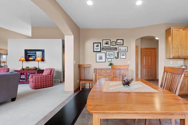 dining space featuring arched walkways, recessed lighting, and visible vents