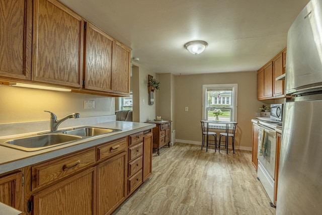 304 Mitchell St, Belleville, WI 53508 - kitchen with light countertops, appliances with stainless steel finishes, a sink, and light wood finished floors