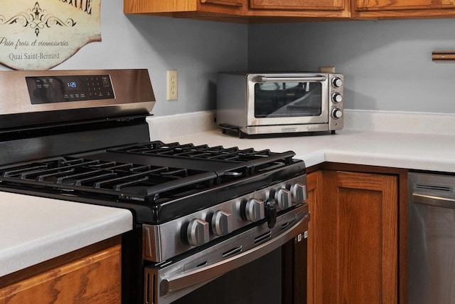 interior details featuring light countertops, stainless steel appliances, brown cabinetry, and a toaster