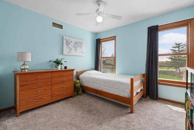 bedroom featuring visible vents, multiple windows, and light colored carpet
