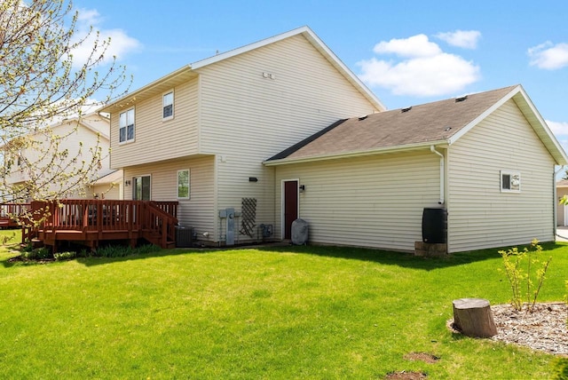 rear view of property with a lawn, a shingled roof, a deck, and cooling unit