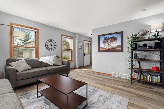 living room with baseboards, wood finished floors, and visible vents