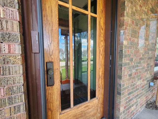 entrance to property featuring brick siding