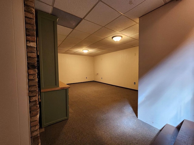 finished below grade area featuring visible vents, carpet flooring, and a paneled ceiling