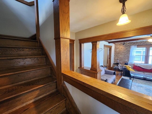 staircase featuring brick wall