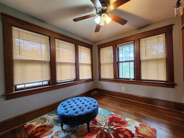 sitting room featuring baseboards, a ceiling fan, and wood finished floors