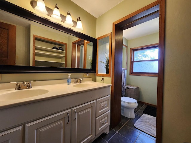 bathroom featuring tile patterned flooring, a sink, double vanity, and toilet