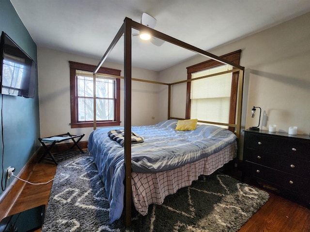 bedroom featuring baseboards, ceiling fan, and wood finished floors