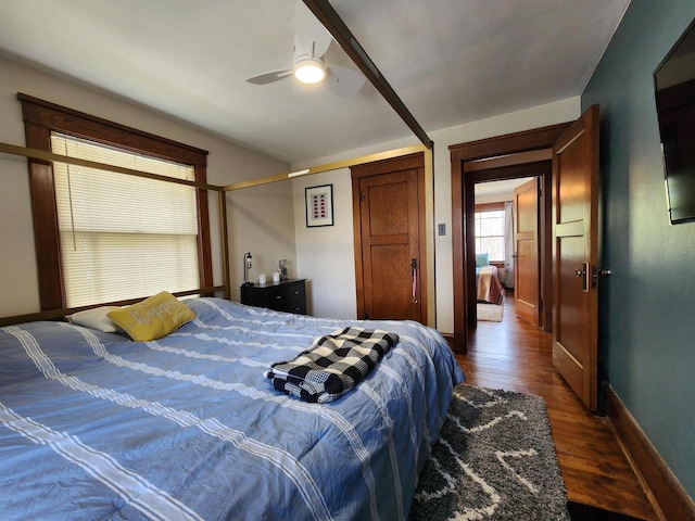 bedroom with baseboards, ceiling fan, and dark wood-style flooring