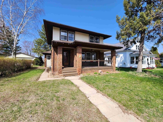 view of front facade featuring brick siding, a ceiling fan, covered porch, and a front yard
