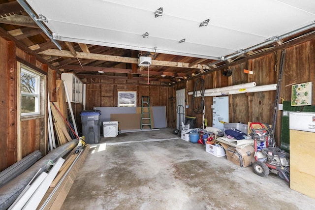 garage featuring a garage door opener and wooden walls