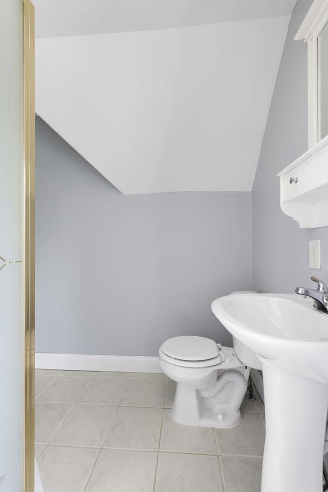 bathroom featuring tile patterned flooring, vaulted ceiling, and toilet