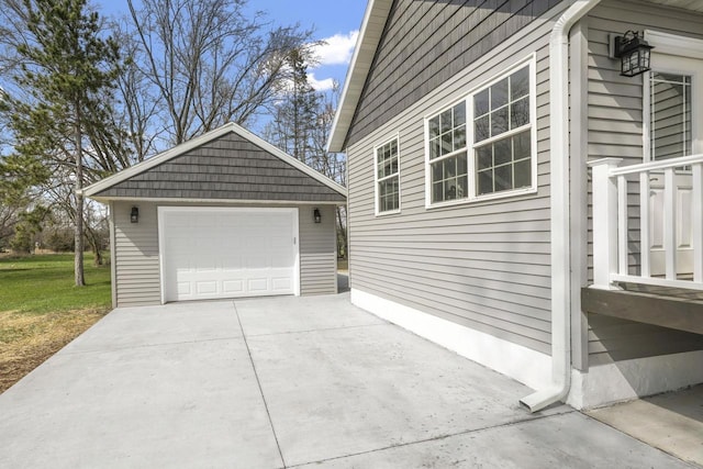 view of home's exterior featuring a garage, an outbuilding, and concrete driveway