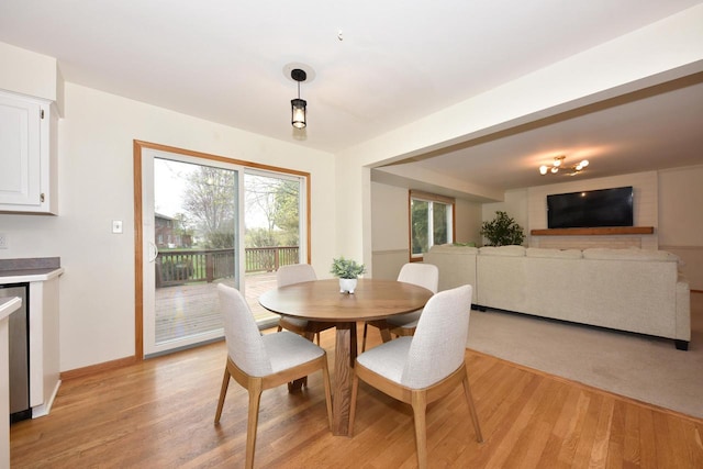 dining space featuring baseboards and light wood-style flooring