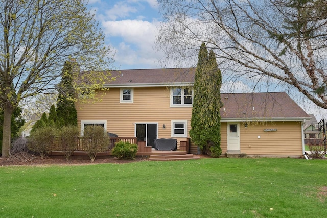back of house featuring a lawn, a chimney, and a deck