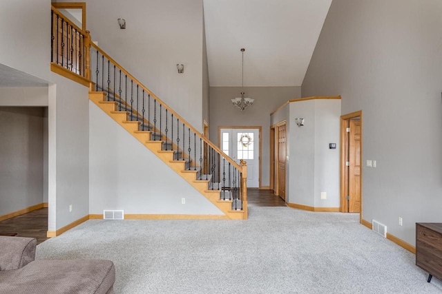 4175 Twilight Ct, Oshkosh, WI 54904 - carpeted entryway with visible vents, a towering ceiling, a notable chandelier, and stairway