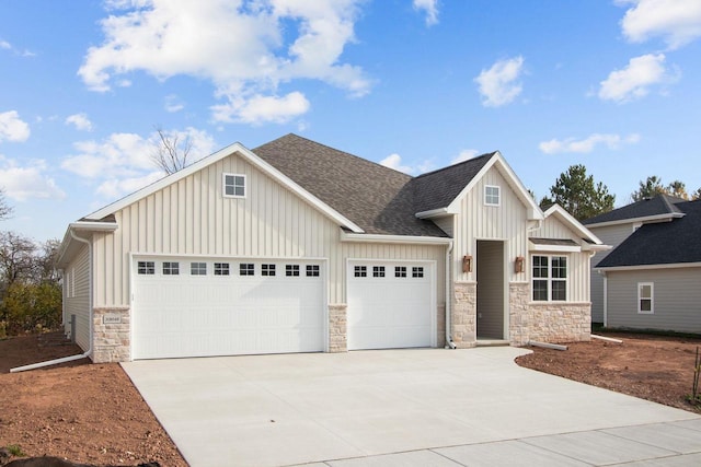 N9046 Southtowne Dr, Menasha, WI 54952 - view of front facade featuring an attached garage, board and batten siding, driveway, and stone siding