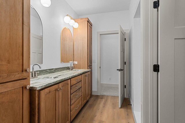 N9046 Southtowne Dr, Menasha, WI 54952 - full bathroom featuring double vanity, a sink, baseboards, and wood finished floors