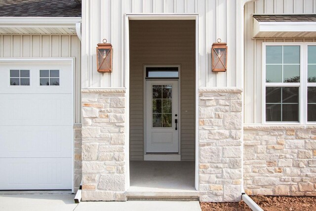 N9046 Southtowne Dr, Menasha, WI 54952 - property entrance featuring a garage, board and batten siding, and stone siding