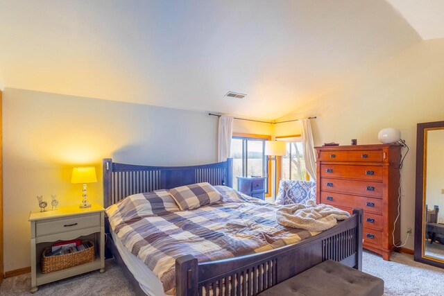carpeted bedroom featuring visible vents and vaulted ceiling