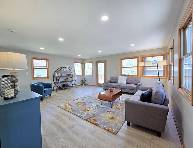 living room with recessed lighting, baseboards, and light wood-type flooring