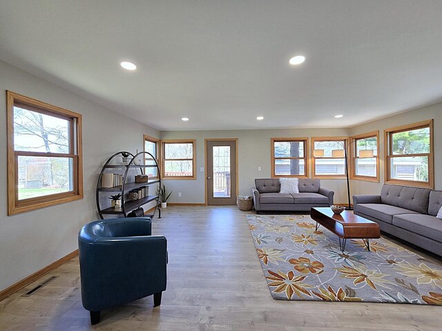 living area featuring baseboards, recessed lighting, and visible vents