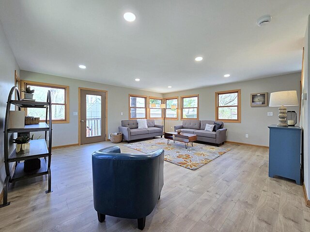living room with baseboards, plenty of natural light, and light wood-style floors