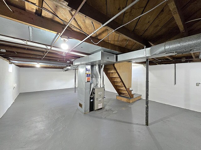 unfinished below grade area featuring heating unit and stairway