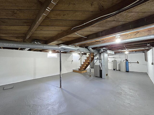 unfinished basement with heating unit and stairs