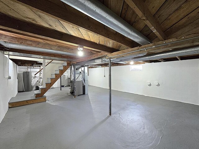 unfinished below grade area with heating unit, water heater, and stairway