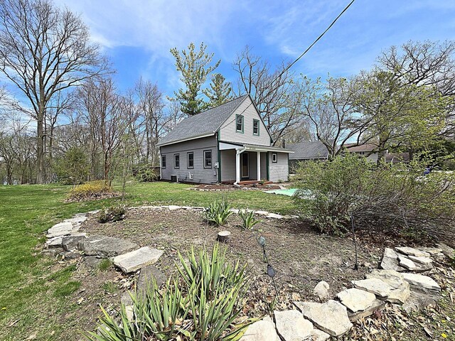 view of front facade featuring a shingled roof and a front lawn