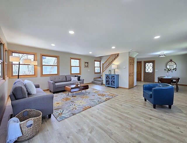 living room featuring stairway, recessed lighting, baseboards, and light wood finished floors