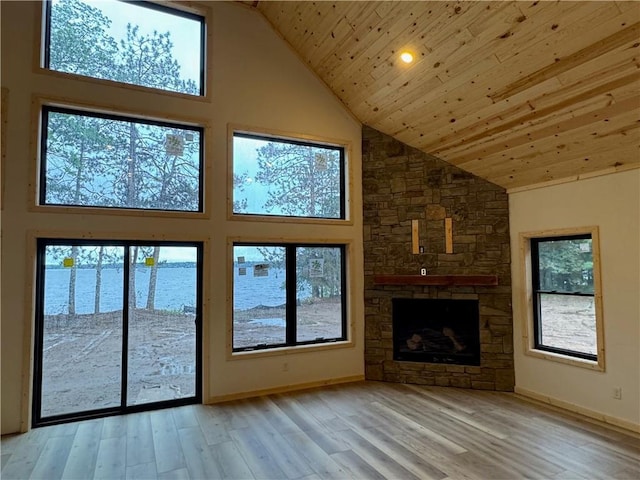 6069 Elsie Rd, Stone Lake, WI 54876 - unfurnished living room with high vaulted ceiling, light wood-style floors, wood ceiling, a stone fireplace, and a water view