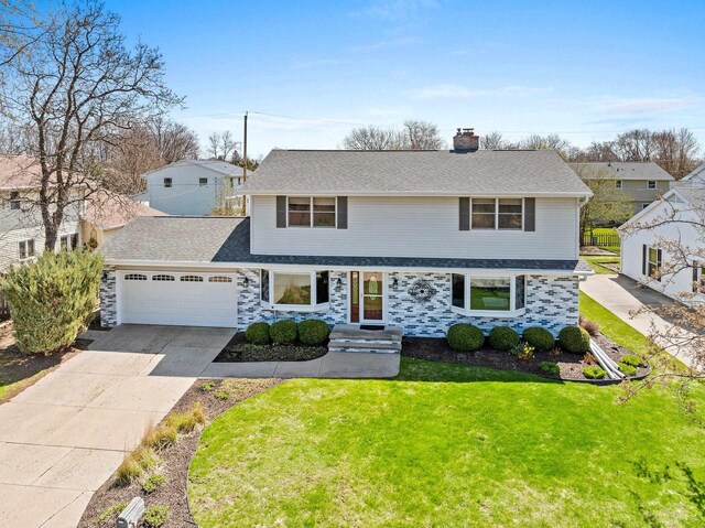 traditional-style home featuring a chimney, a front lawn, concrete driveway, an attached garage, and a shingled roof