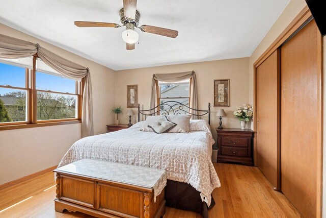 bedroom with ceiling fan, a closet, and light wood-type flooring