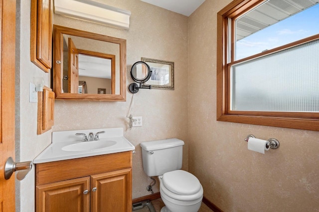 half bathroom featuring an AC wall unit, toilet, and vanity