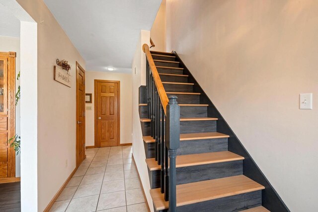 staircase with tile patterned floors and baseboards