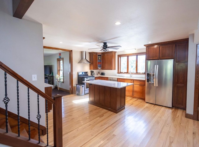 1694 Washington St, Verona, WI 53593 - kitchen featuring stainless steel appliances, wall chimney range hood, light wood-type flooring, a sink, and ceiling fan