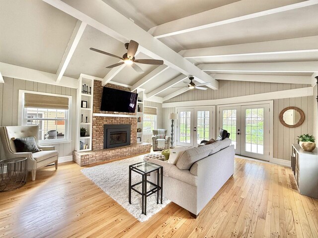852 Sherwood Dr NW, Beloit, WI 53511 - living room with a brick fireplace, lofted ceiling with beams, light wood-type flooring, french doors, and a ceiling fan