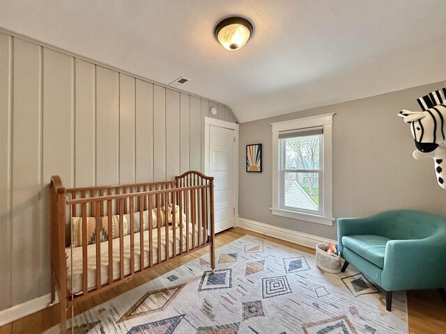 852 Sherwood Dr NW, Beloit, WI 53511 - bedroom featuring baseboards, visible vents, wood finished floors, and lofted ceiling