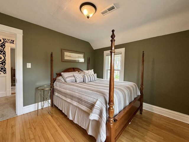 852 Sherwood Dr NW, Beloit, WI 53511 - bedroom featuring baseboards, vaulted ceiling, light wood finished floors, and visible vents