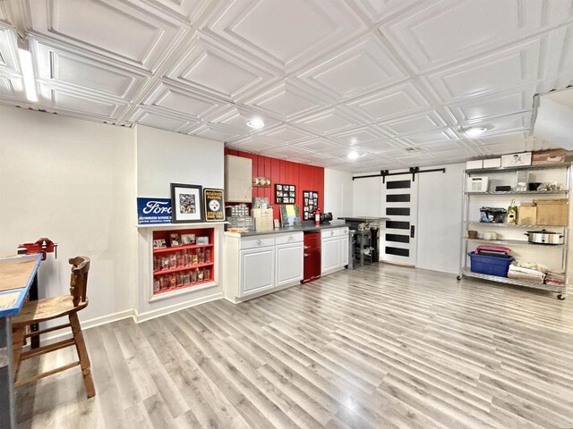 852 Sherwood Dr NW, Beloit, WI 53511 - bar featuring bar, a barn door, baseboards, an ornate ceiling, and light wood-style flooring
