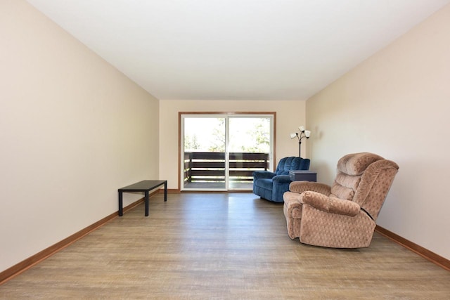 living area featuring baseboards and wood finished floors