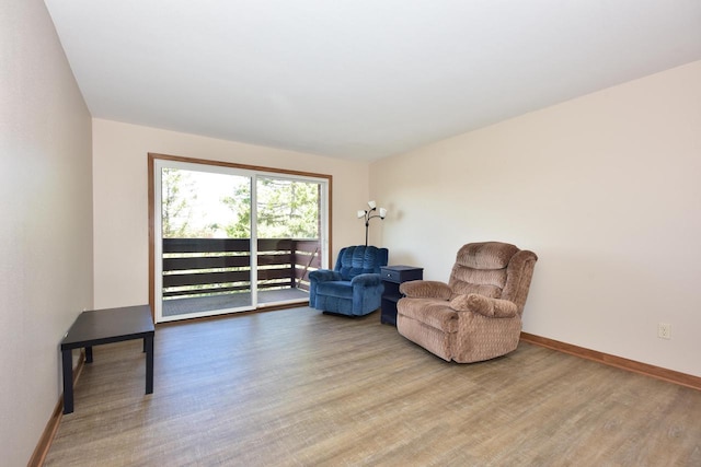 living area featuring baseboards and wood finished floors