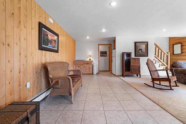 living area with wooden walls, recessed lighting, light tile patterned floors, and stairs