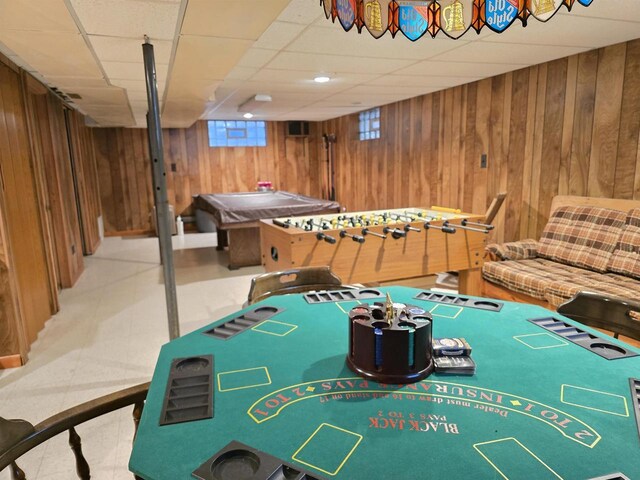 rec room with wood walls and a drop ceiling