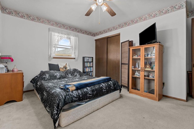 carpeted bedroom featuring baseboards, a ceiling fan, and a closet
