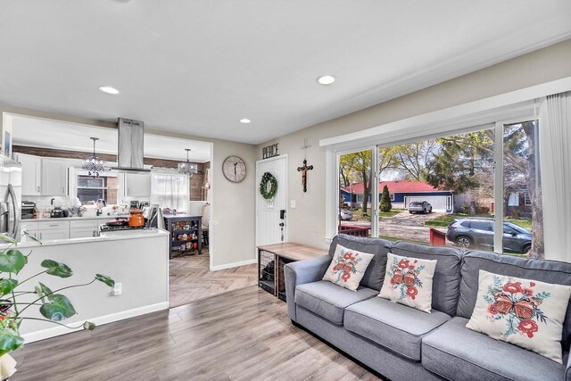 living room featuring recessed lighting, baseboards, a notable chandelier, and parquet floors